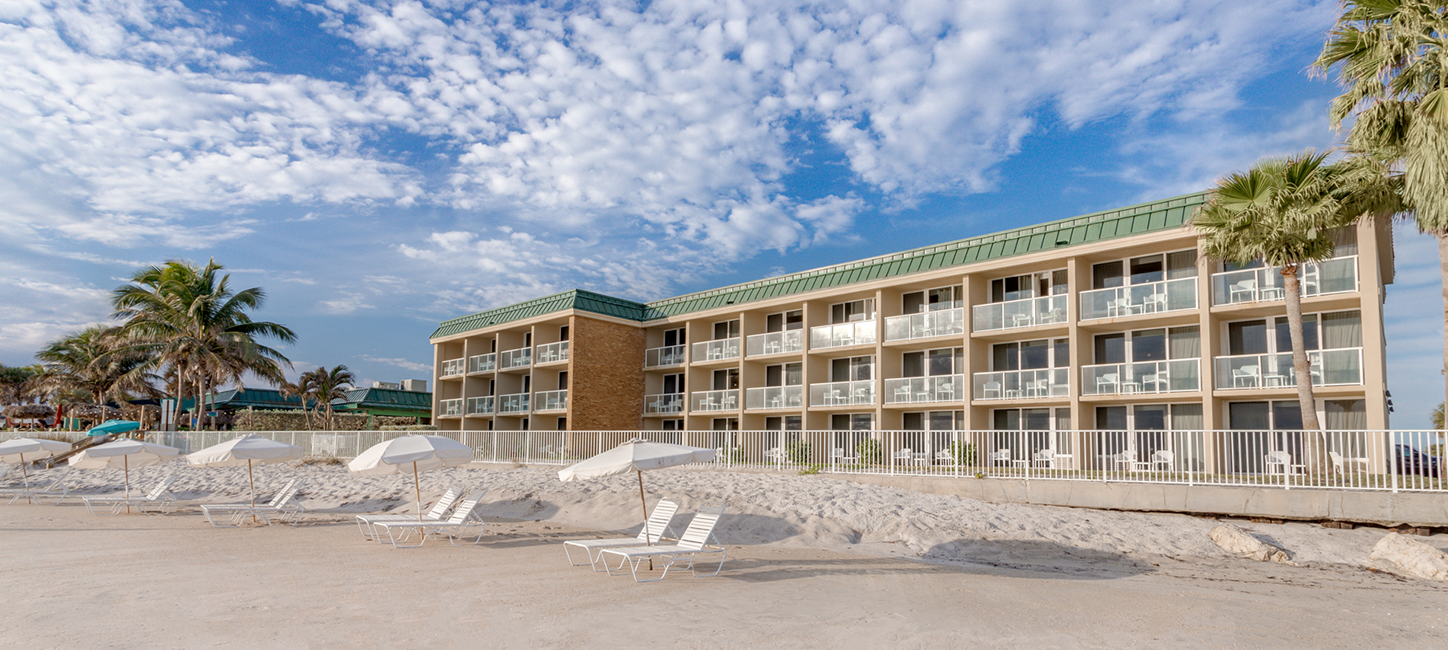 view of the hotel from the beach with beach chairs on the beach