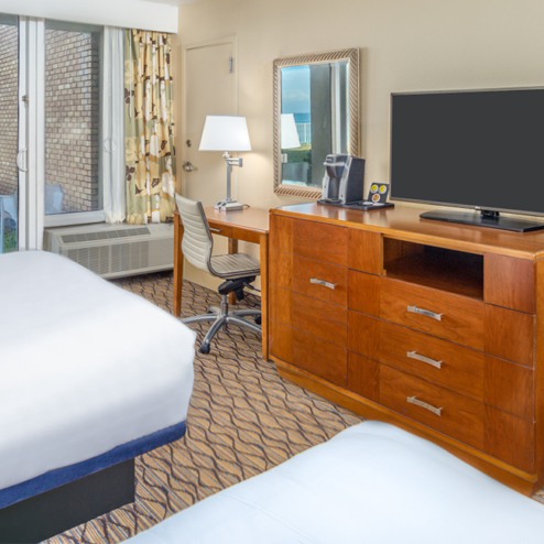 ocean view hotel room with two double beds and a tv