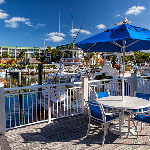 A blue umbrella on a deck.