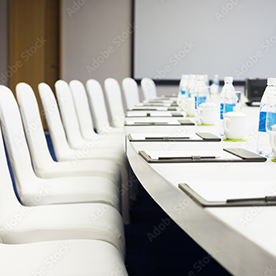 A conference room with white chairs.
