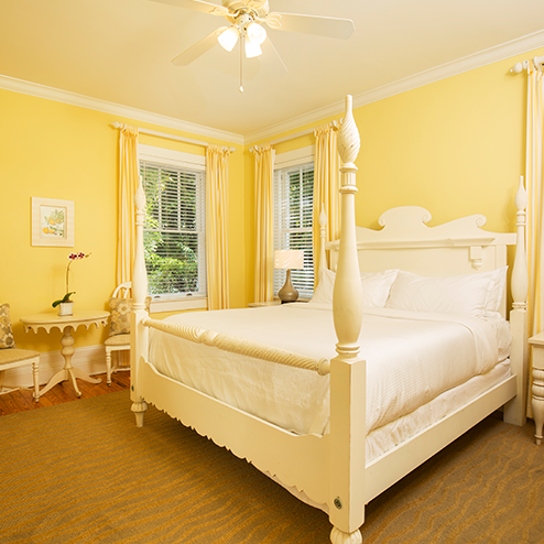 A bed in a room with yellow walls.