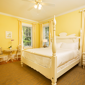 A yellow bedroom with a four poster bed.