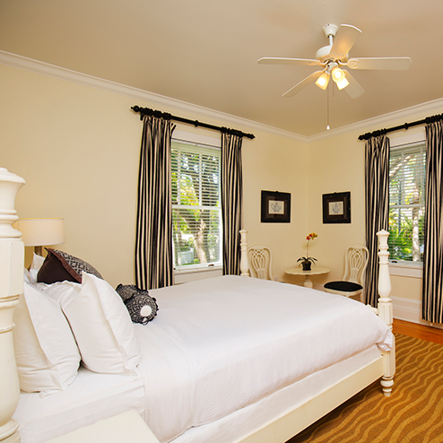 A bed in a bedroom with a fan.