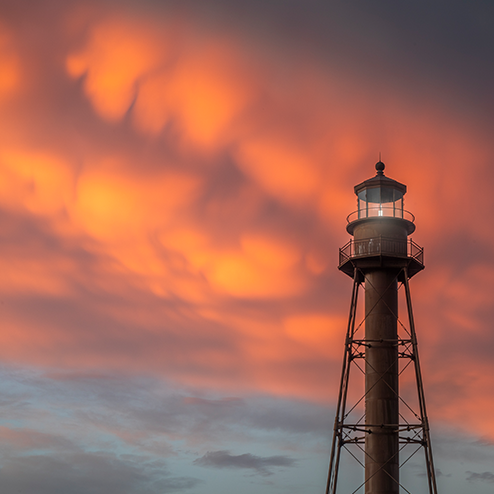 A lighthouse under a cloudy sky.