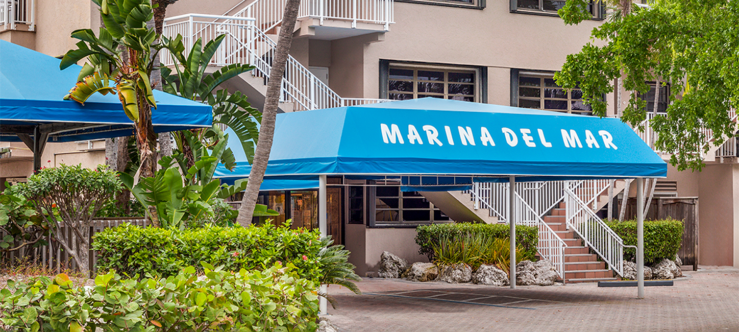 Entrance to a building with a blue awning displaying the text 