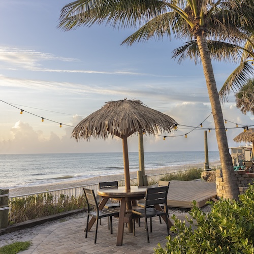 Mulligans beachfront patio table with tiki hut