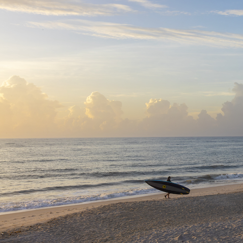 Sunrise on Vero Beach with surfer
